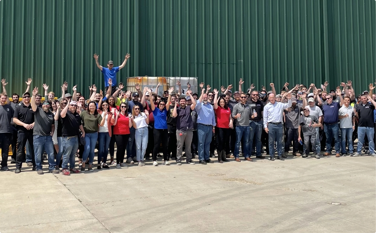 Large team of people with their hands raised