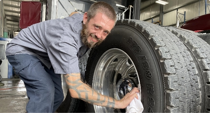 Mechanic polishing the chrome inside a semi truck tire