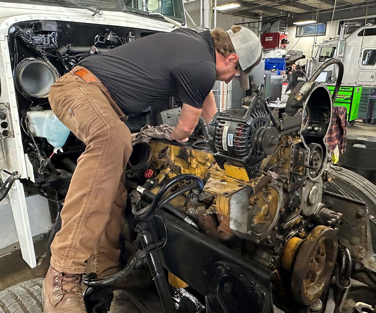 Mechanic operating on a semi truck engine