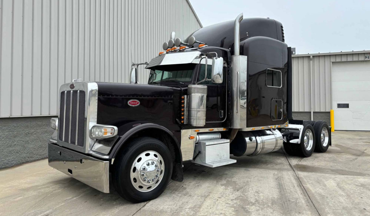 A black peterbilt 379 semi truck parked in front of a building