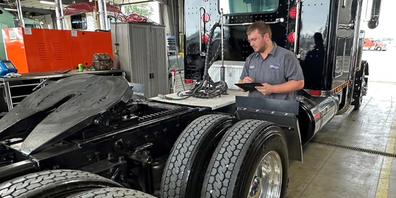 appraiser inspecting used semi-truck in auto shop