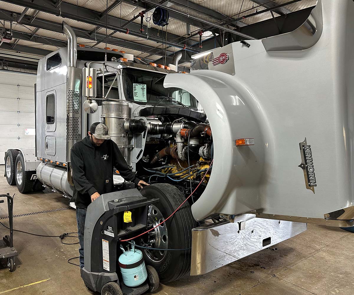 Mechanic inspecting a Kenworth semi truck